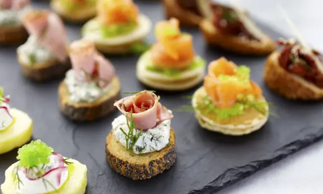 Deliciosos entrantes navideños: canapés variados con salmón, jamón, queso y patata. ¡Perfectos para celebrar!
