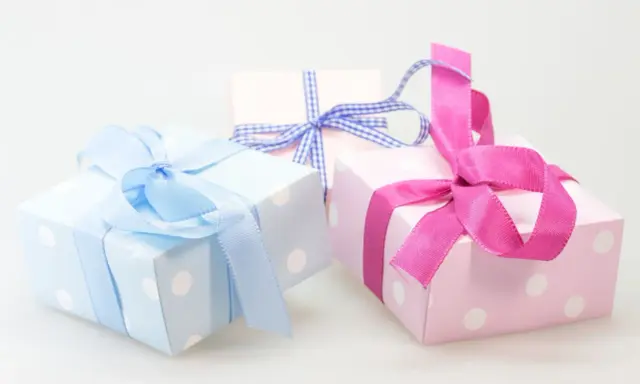 Cajas de regalo con lunares, envueltas en cintas rosas y azules. ¡Perfectas para ideas originales con chuches!