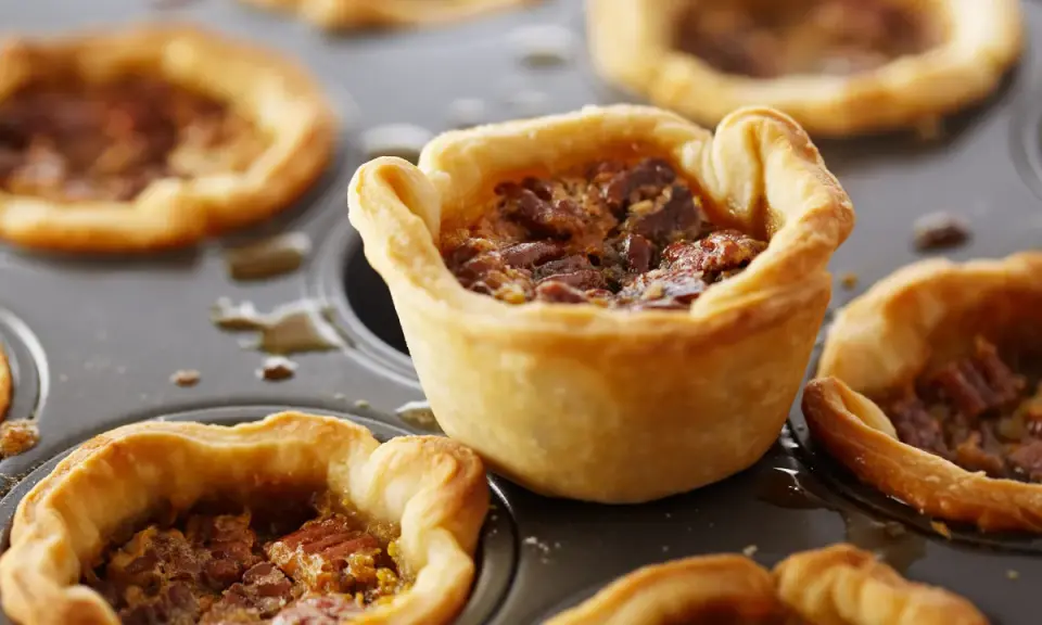 Mini tartas de nuez en molde, perfectas para recetas con masa quebrada.