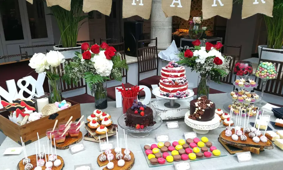 Una mesa dulce boda con pasteles, cupcakes, macarons y flores. ¡Un festín para los ojos y el paladar!