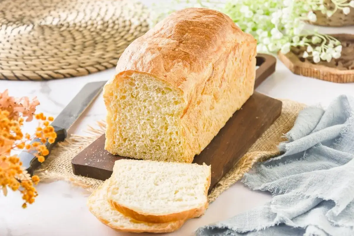 Un pan de patata dorado y esponjoso, recién cortado, sobre una tabla de madera.