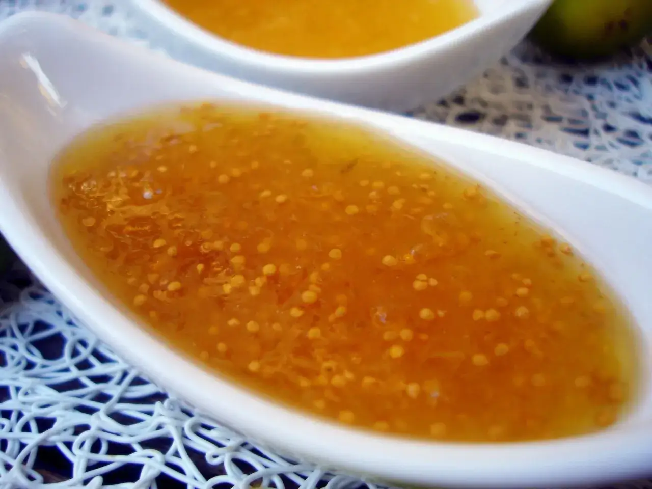 Mermelada de higos casera, dorada y dulce, servida en un cuenco blanco sobre un mantel de encaje.