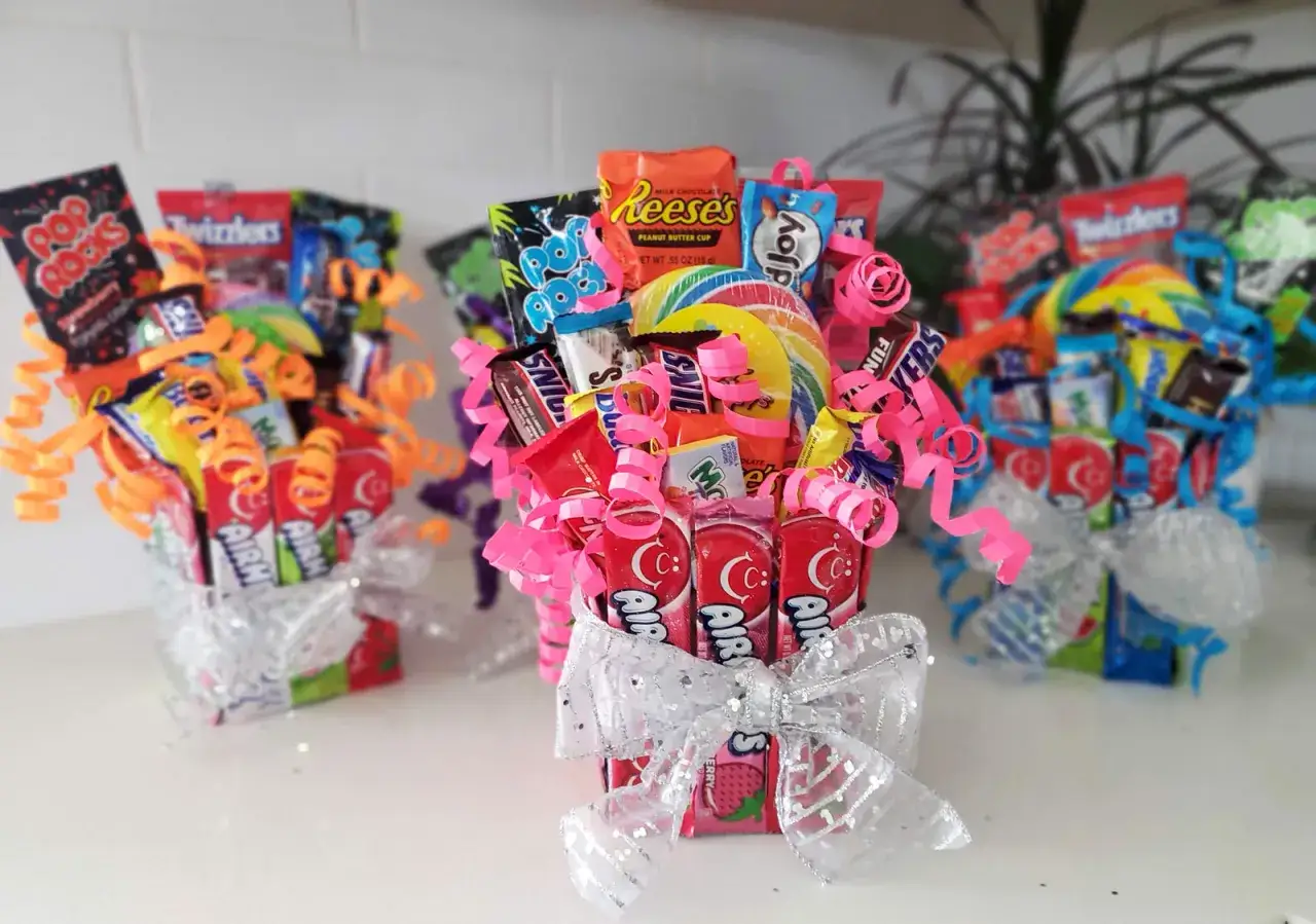 Arreglos de chuches coloridos, perfectos como manualidades para regalar. Incluyen dulces variados, lazos brillantes y papel celofán.