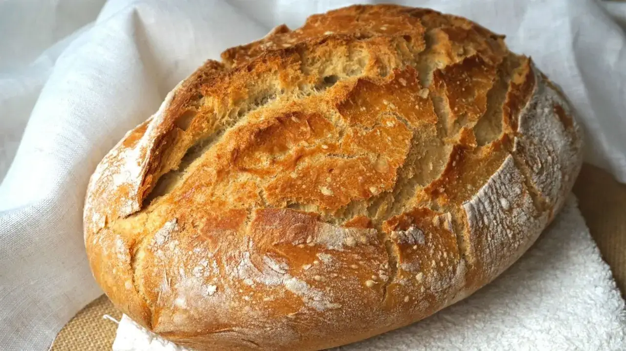 Pan casero recién horneado, con corteza dorada y crujiente. Perfecto para tu próxima receta de pan casero.