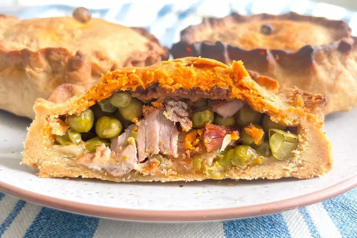 Empanadas mallorquinas rellenas de carne y guisantes, con masa dorada y crujiente.