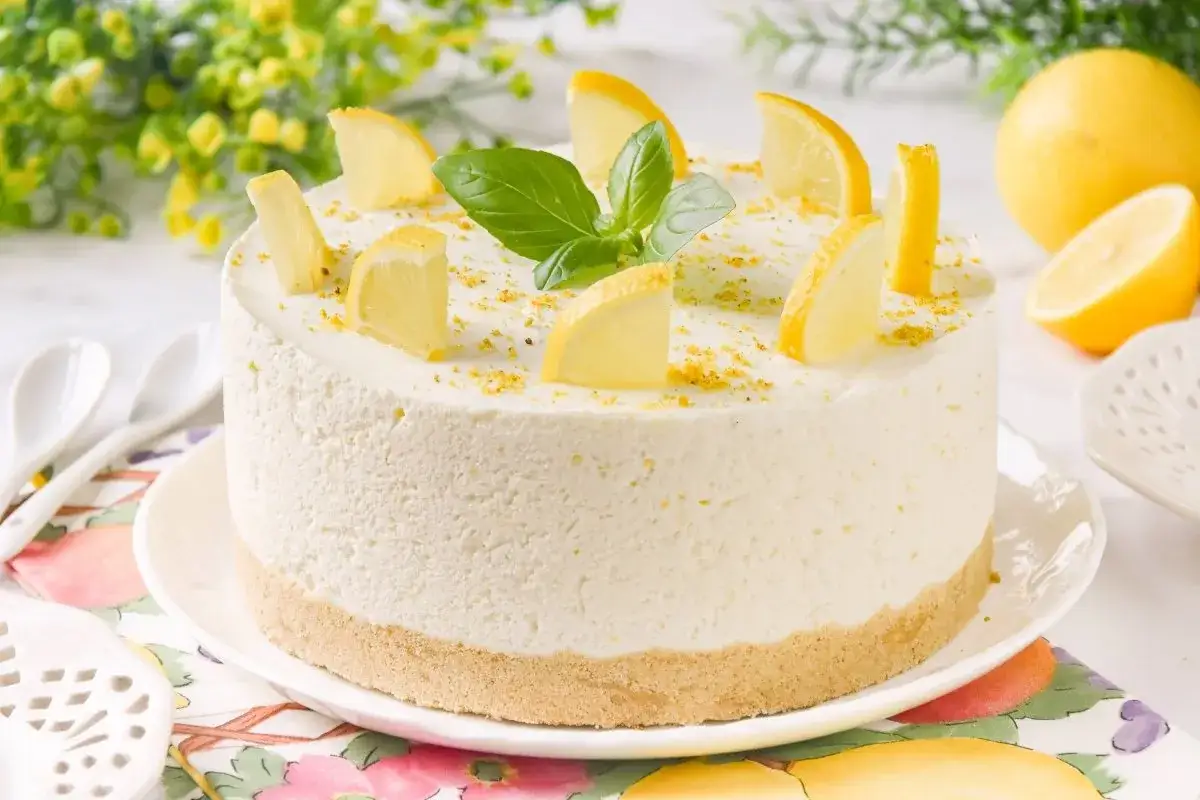 Delicioso mousse de limón receta original, decorado con rodajas de limón y hojas verdes.