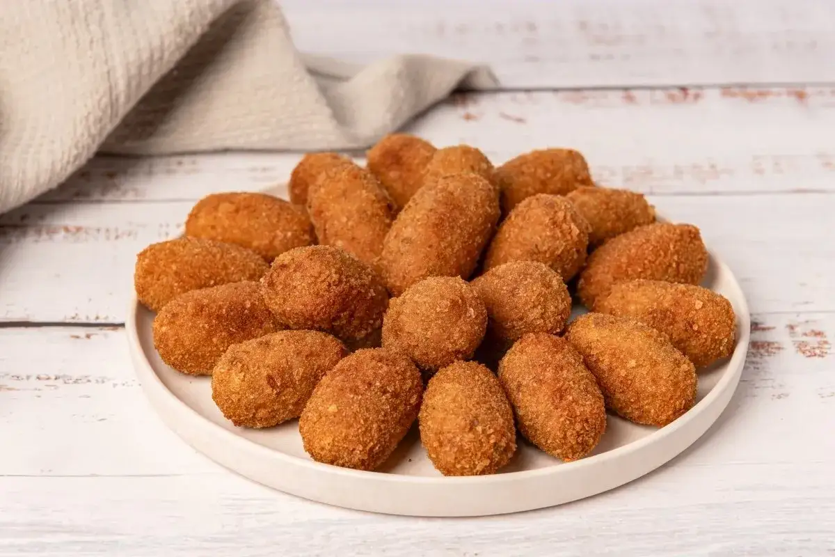 Plato lleno de croquetas caseras doradas y crujientes, listas para disfrutar.