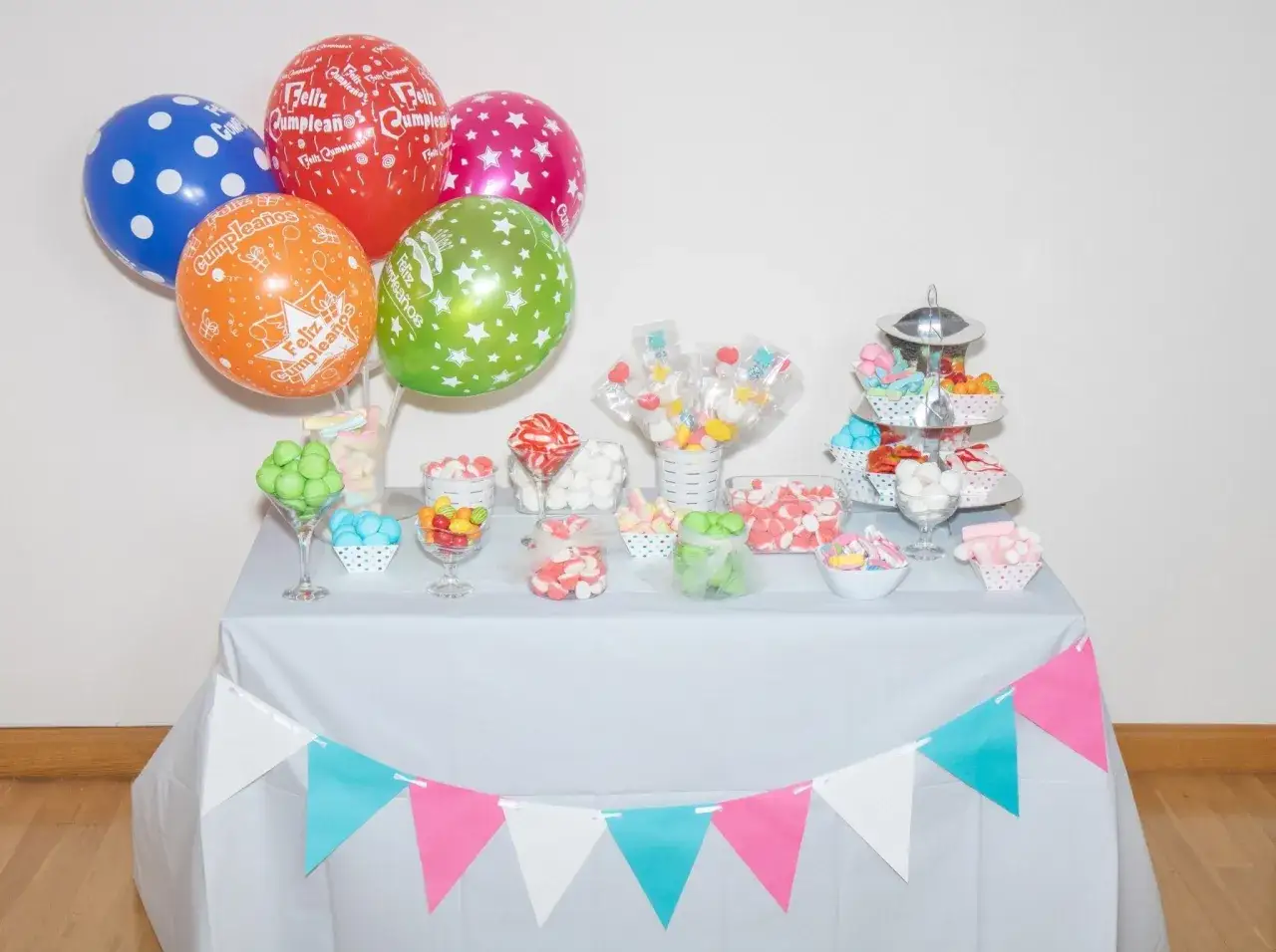 Mesa llena de chuches y globos para una fiesta. ¡Ideal para aprender como hacer bolas de chuches!