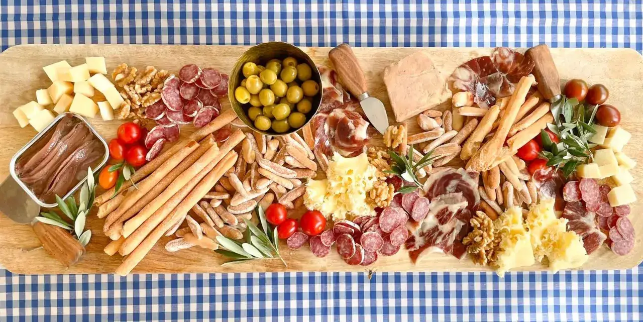 Tabla de quesos y embutidos con aceitunas, tomates cherry, nueces y anchoas. ¡Perfecta para compartir y tener pica pica ideas!