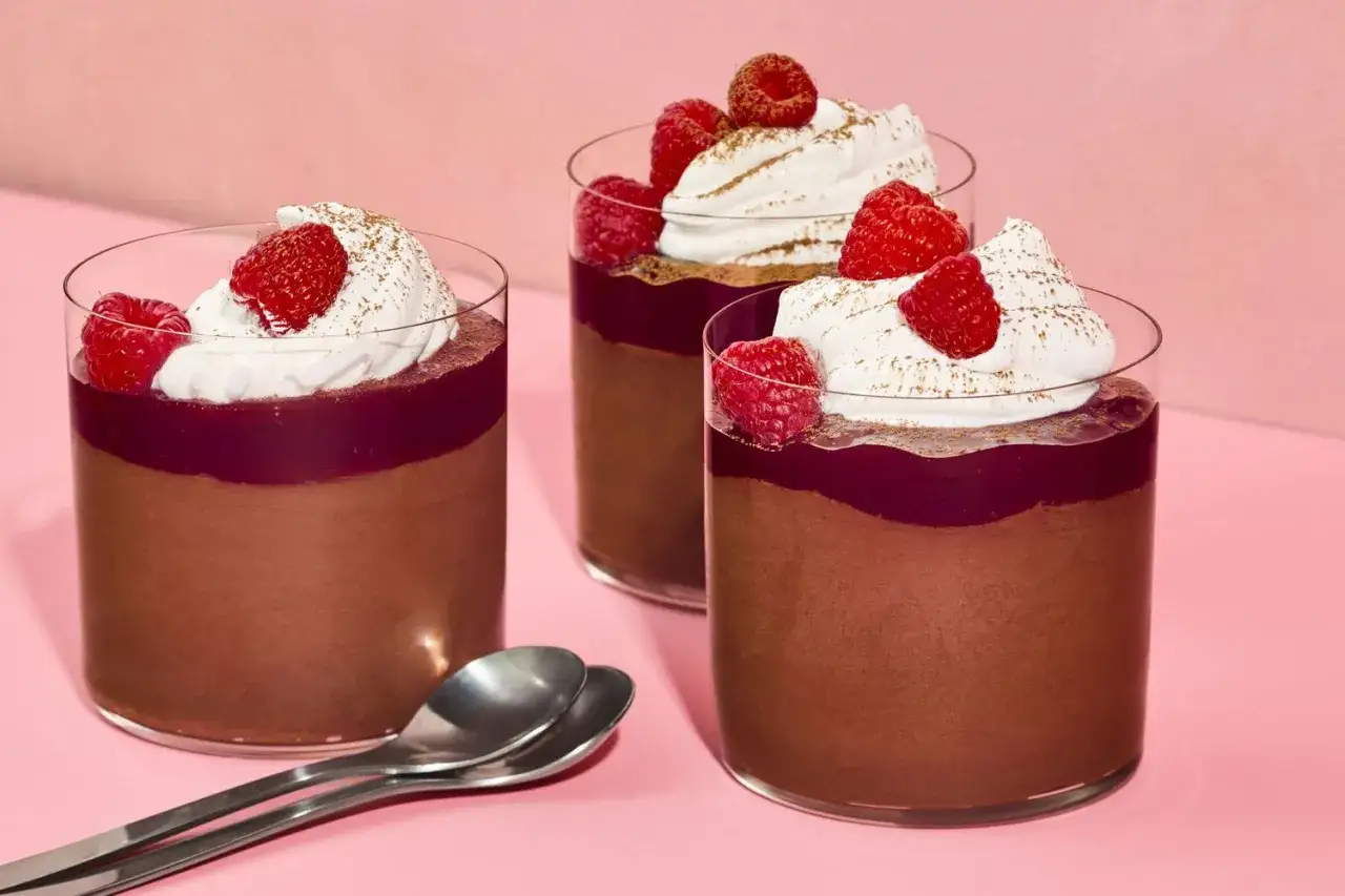 Delicioso mousse de chocolate con capa de frutos rojos, crema batida y frambuesas frescas. ¡Un postre irresistible!