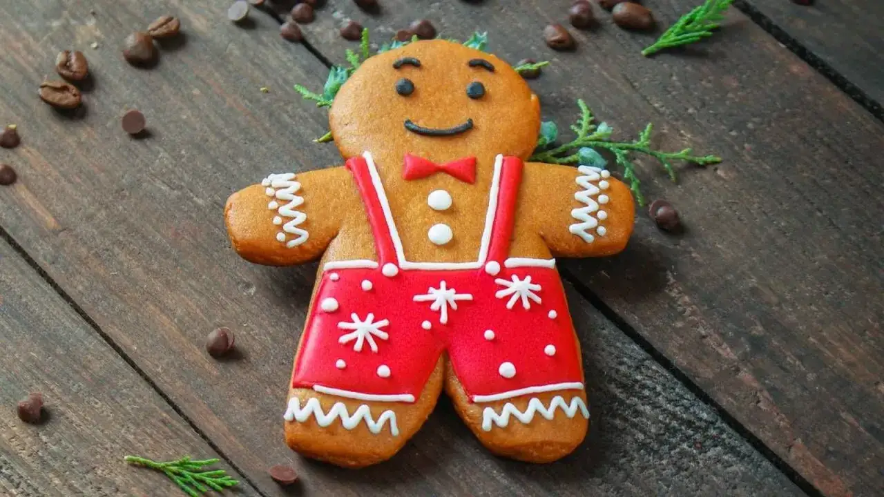 Un simpático hombre de jengibre con traje rojo y pajarita, listo para celebrar las galletas de jengibre de Navidad.