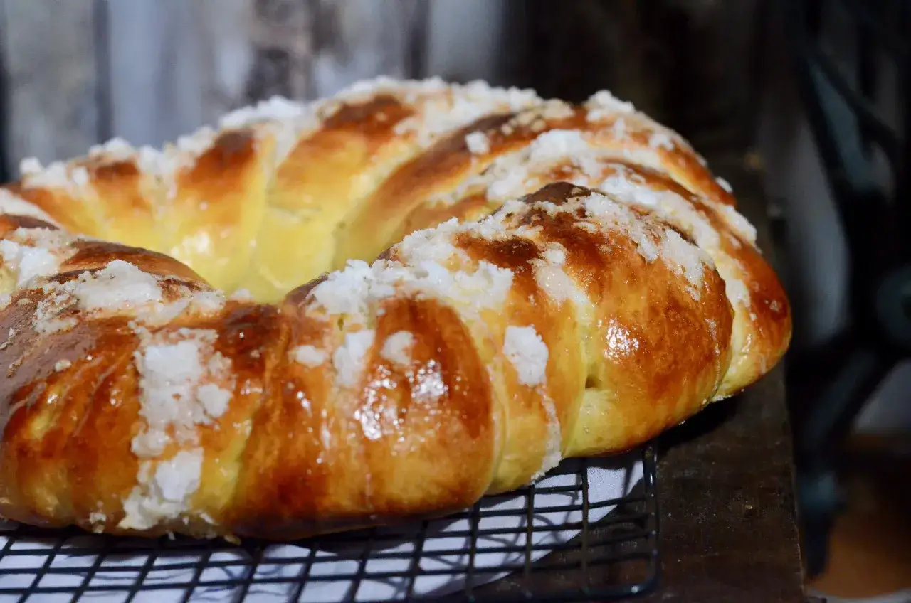 Rosca de Pascua gallega dorada y brillante, cubierta de azúcar crujiente, lista para celebrar.