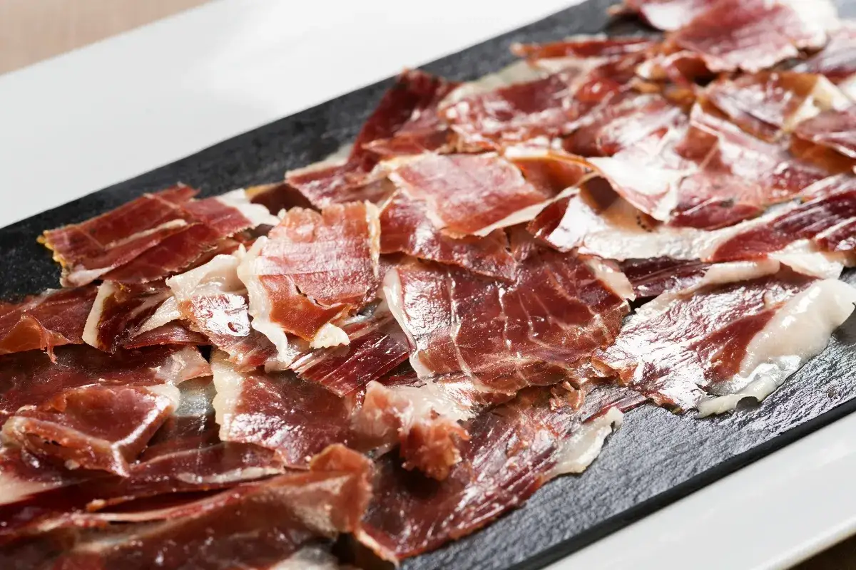 Finas lonchas de jamón serrano, perfectos aperitivos para sorprender a tus invitados con un sabor auténtico.