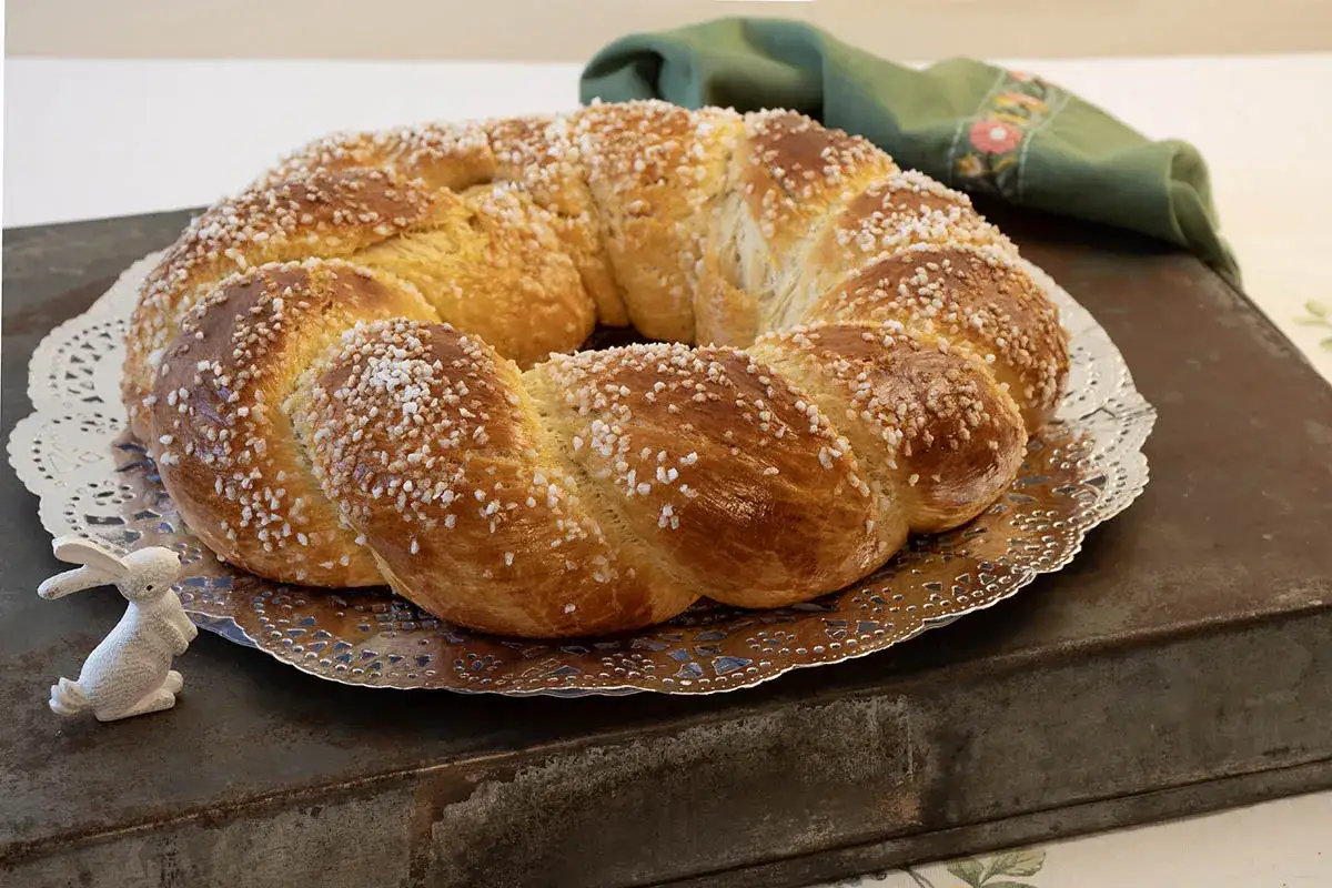 Rosca de Pascua gallega, trenzada y espolvoreada con azúcar, lista para celebrar la Pascua junto a un conejito decorativo.
