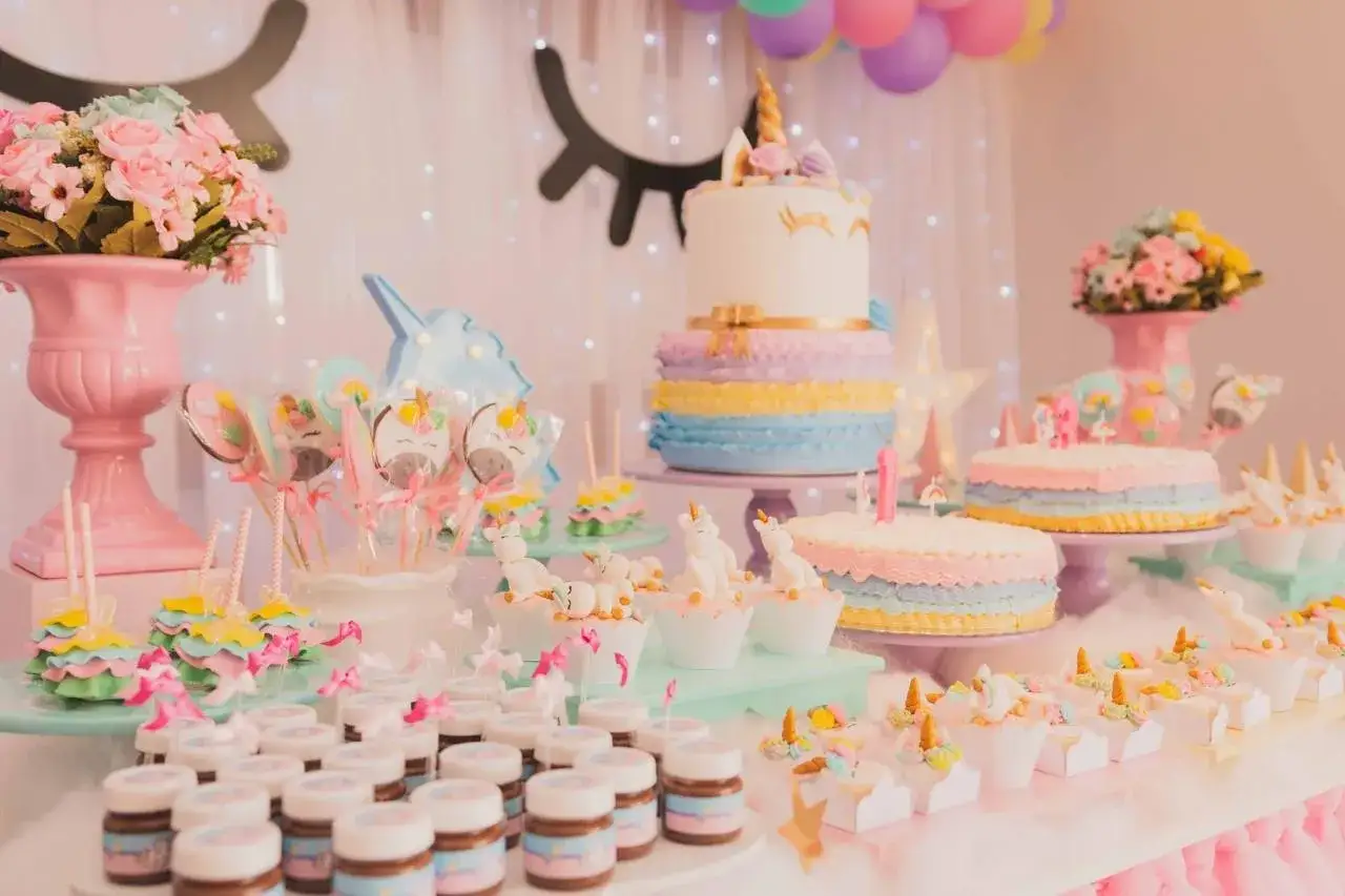 Mesa de fiesta temática unicornio con pastel, cupcakes y un precioso ramo de chuches casero.