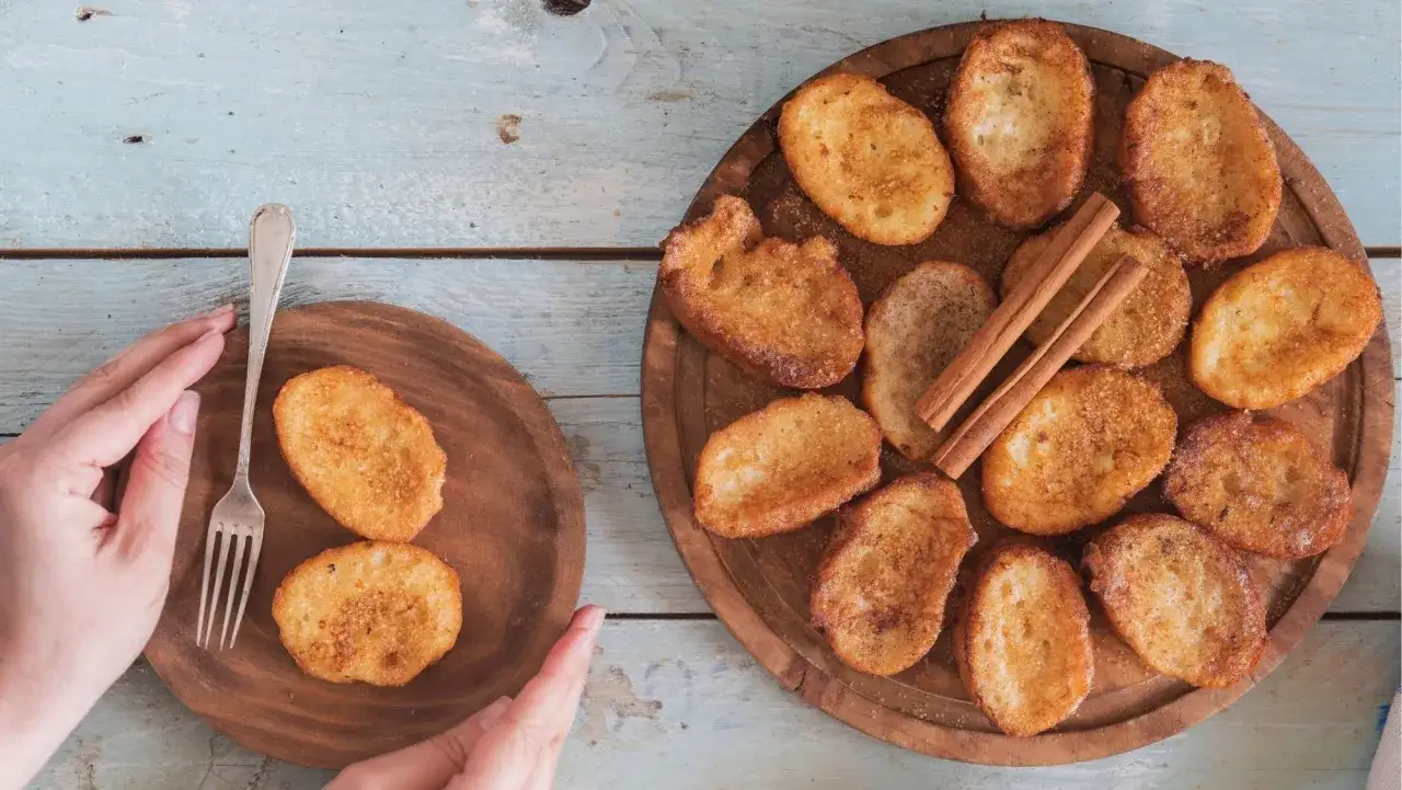 Torrijas doradas espolvoreadas con azúcar y canela, listas para disfrutar. Los ingredientes básicos para unas torrijas perfectas.
