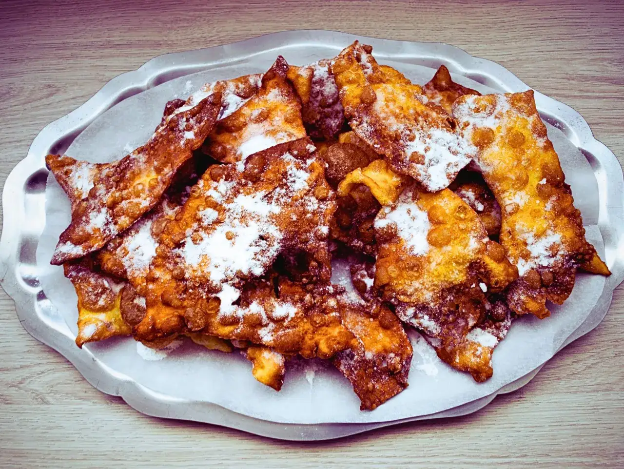 Orejas de carnaval crujientes y doradas, espolvoreadas con az&uacute;car glas. Una deliciosa receta para disfrutar en fiestas.