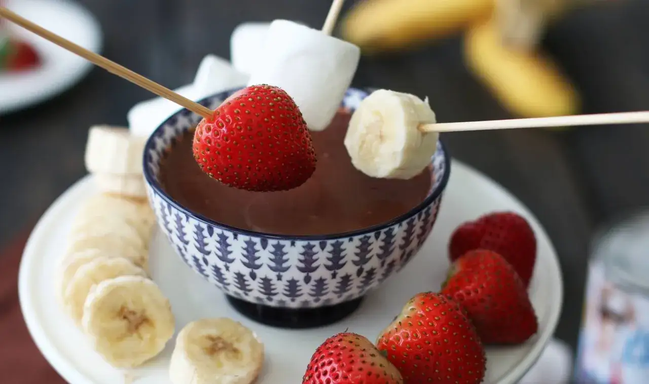Fresas y plátanos listos para sumergir en una deliciosa fondue de chocolate. ¡Una receta fácil y tentadora!