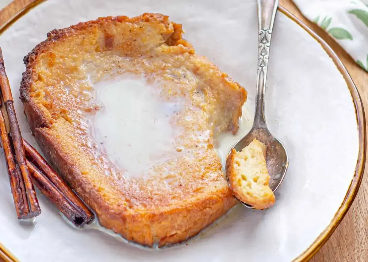 Torrijas caseras con leche condensada, canela y una cucharada lista para disfrutar.