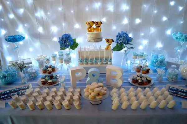 Mesa de dulces para una boda sencillo: pastel con perritos, cupcakes, macarons y postres individuales.