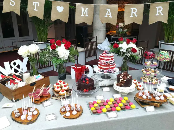 Una mesa dulce boda con pasteles, cupcakes, macarons y flores. ¡Un festín para los ojos y el paladar!
